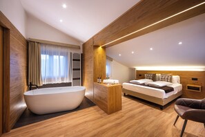 A modern bedroom with a large bathtub, a neatly made bed, and a wooden ceiling. - Hotel Iris (Pescasseroli)