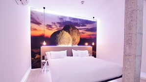 Een moderne slaapkamer met een groot bed, een tv aan de muur en een minimalistisch design.