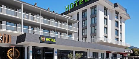 A modern hotel with a prominent 'HOTEL' sign, a Burger King, and a B&B sign.