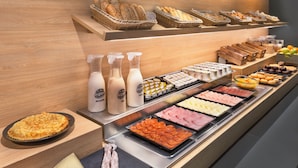 Een buffet met diverse gerechten, zoals brood, kaas en vleeswaren.