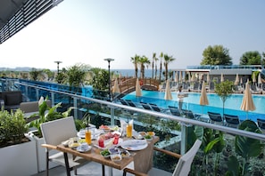 A dining area with a view of a pool and palm trees. - Selene Beach & Spa Hotel (Alanya)