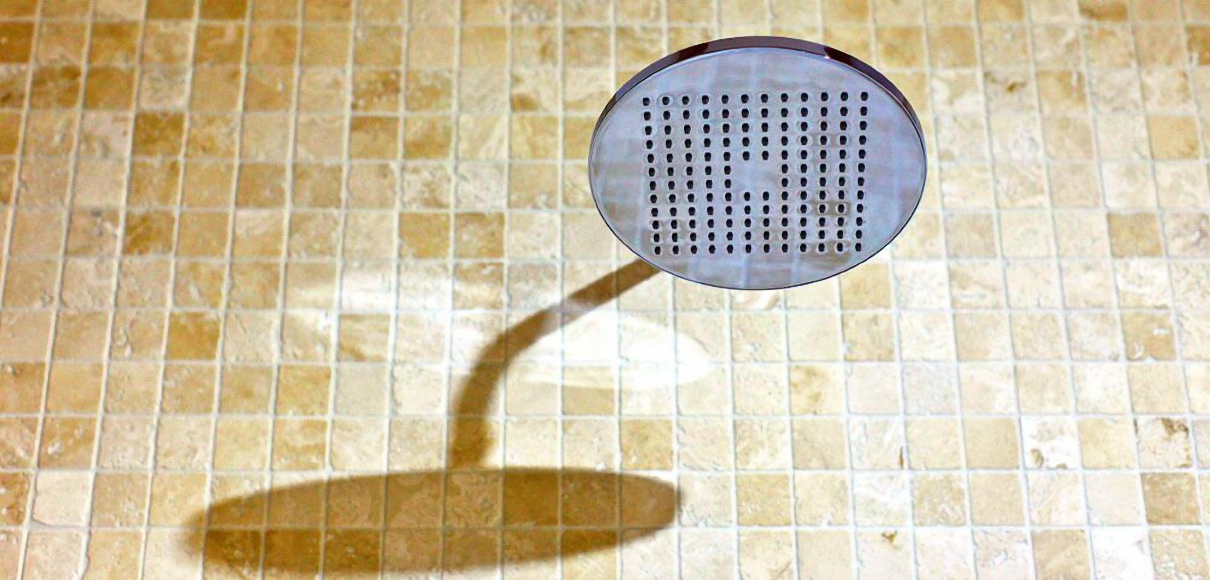 Un suelo de baldosas con un objeto circular proyectando una sombra.
