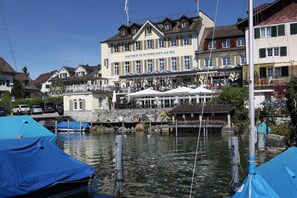 A riverside building with a sign reading "GASTHOF ZUM HIRSCHEN AM SEE". - Hotel Hirschen am See (Meilen)