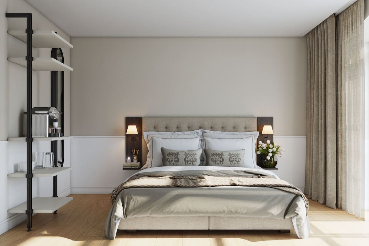 A bedroom with a bed, bedside tables, a bookshelf, and a window with curtains.