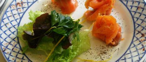Un plato de salmón, lechuga y salsa cremosa.