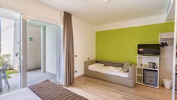Une chambre d’hôtel moderne équipée d’un lit, d’un canapé, d’une télévision et d’un mini-réfrigérateur.