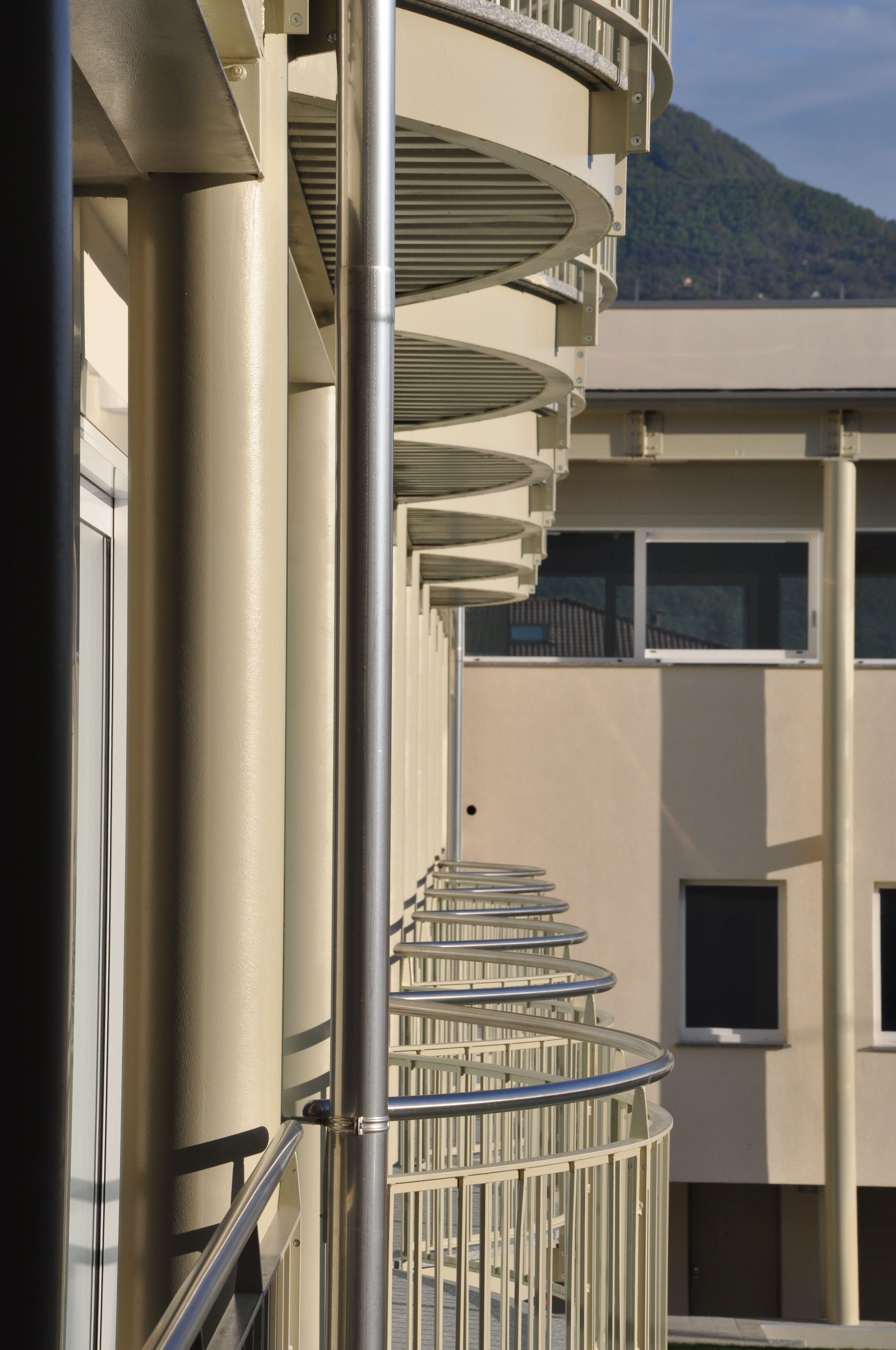 Eine Wendeltreppe mit Metallgeländern, die zu einem Balkon mit Bergblick führt.