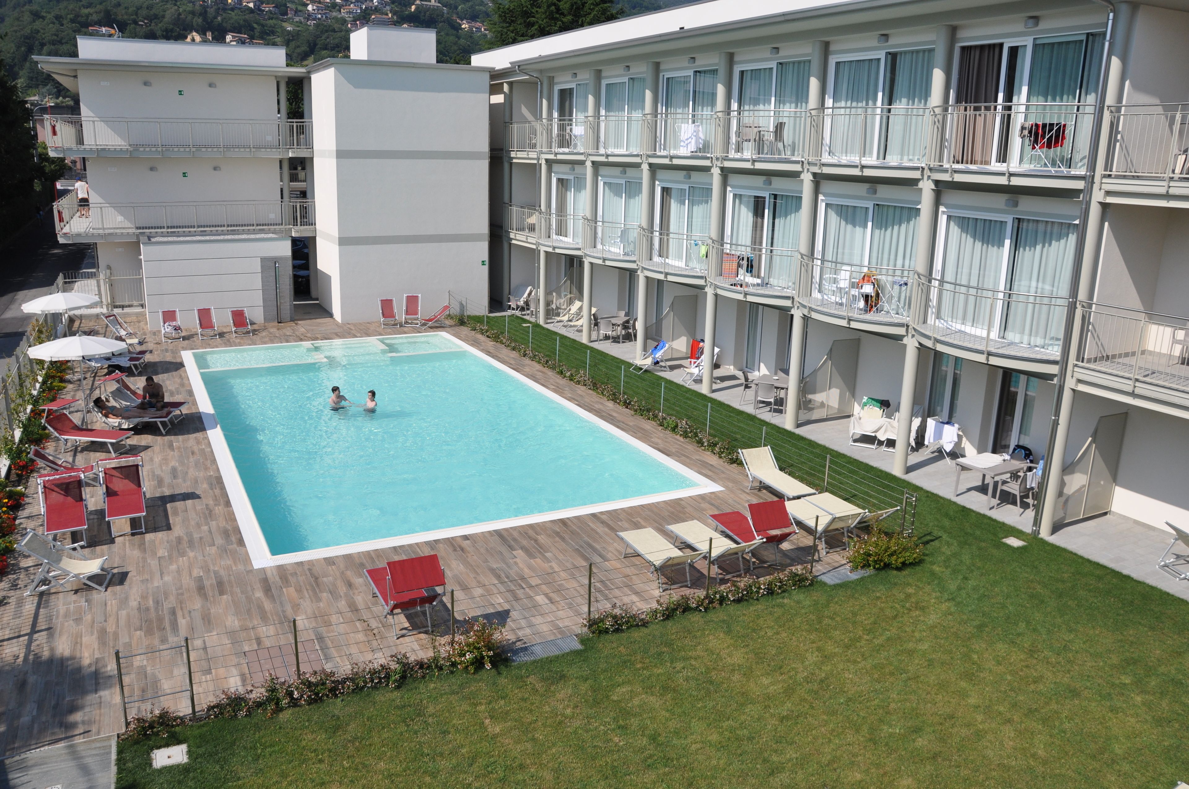 Ein Hotel mit Schwimmbad, mehreren Balkonen und Sitzgelegenheiten im Freien.