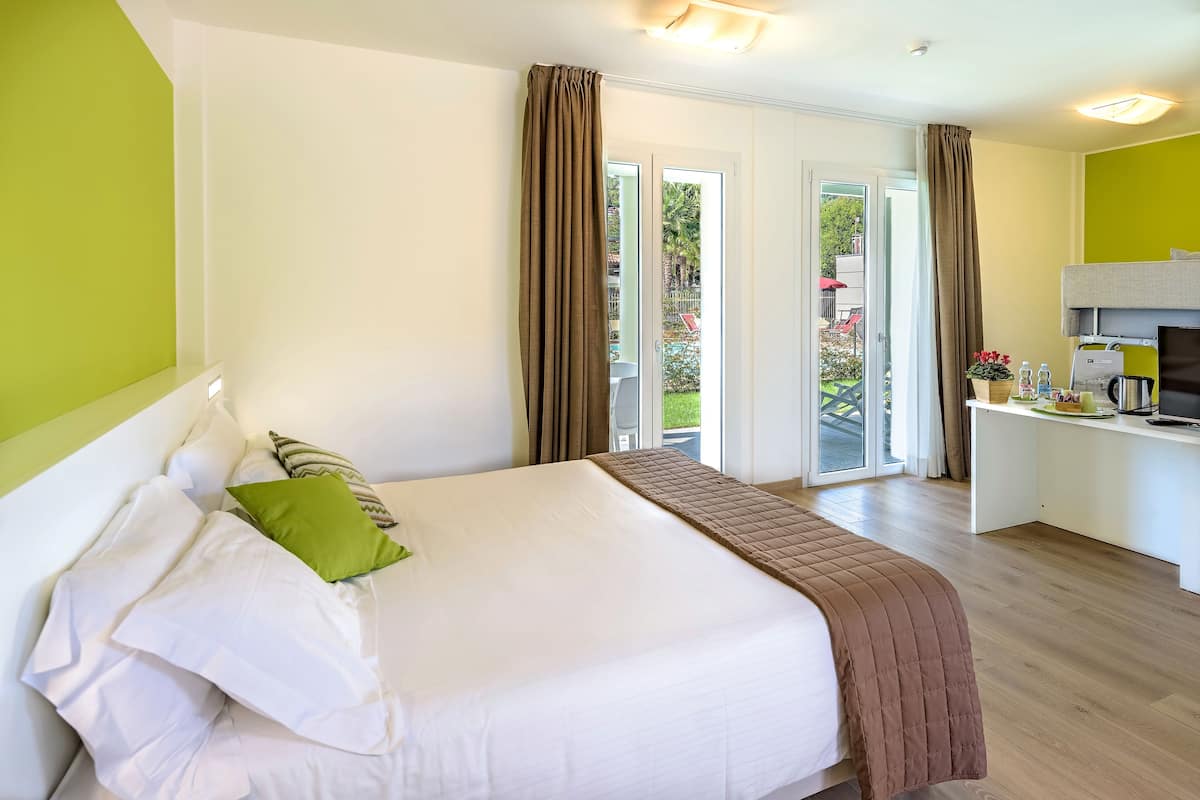 Une chambre d’hôtel avec un lit, un bureau et une vue sur l’extérieur.