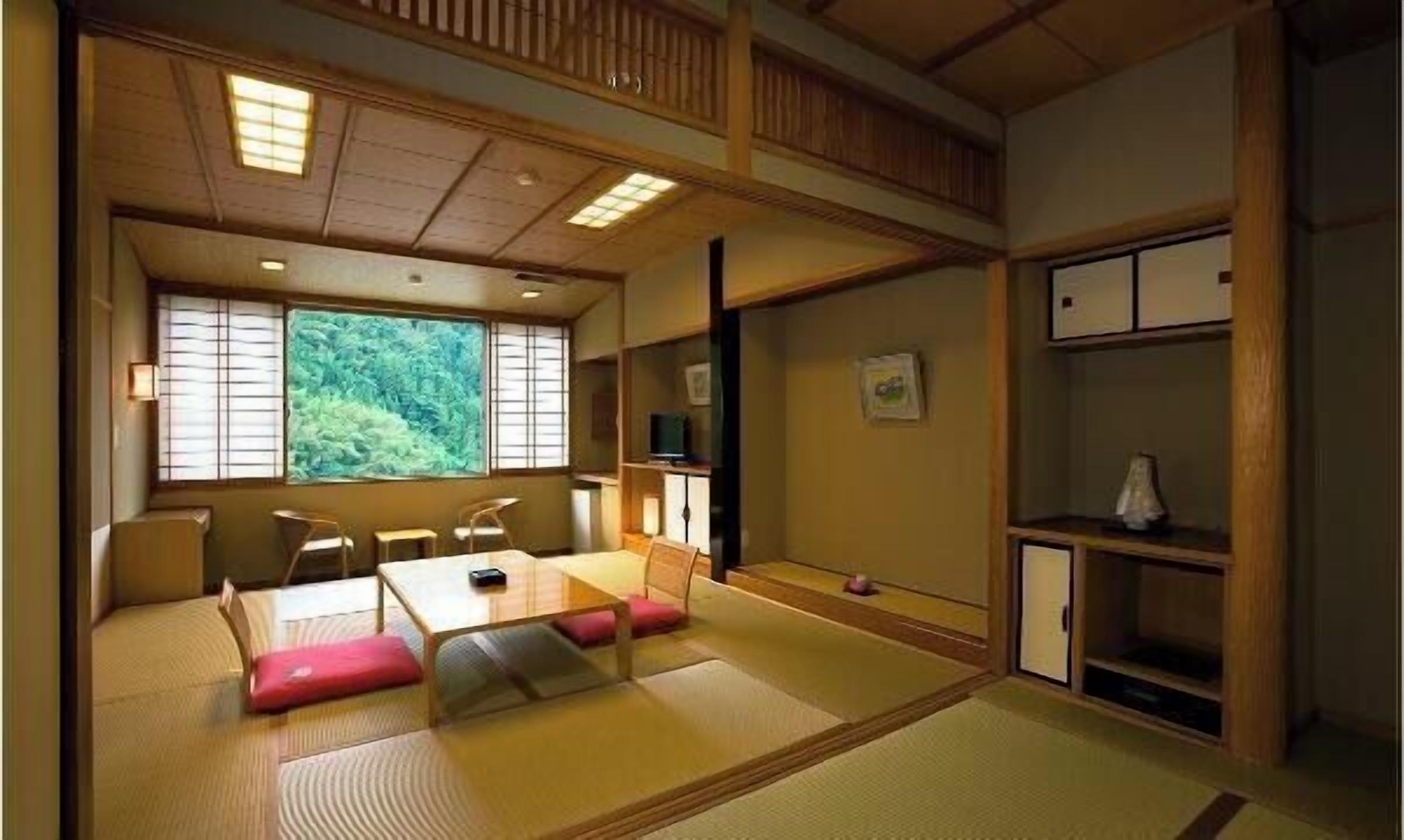 Une pièce de style japonais traditionnel, avec un sol recouvert de tatamis, une table basse avec des coussins et des portes coulissantes.