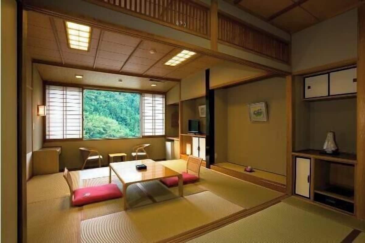 A traditional Japanese room with tatami flooring, a low table with cushions, and sliding doors.