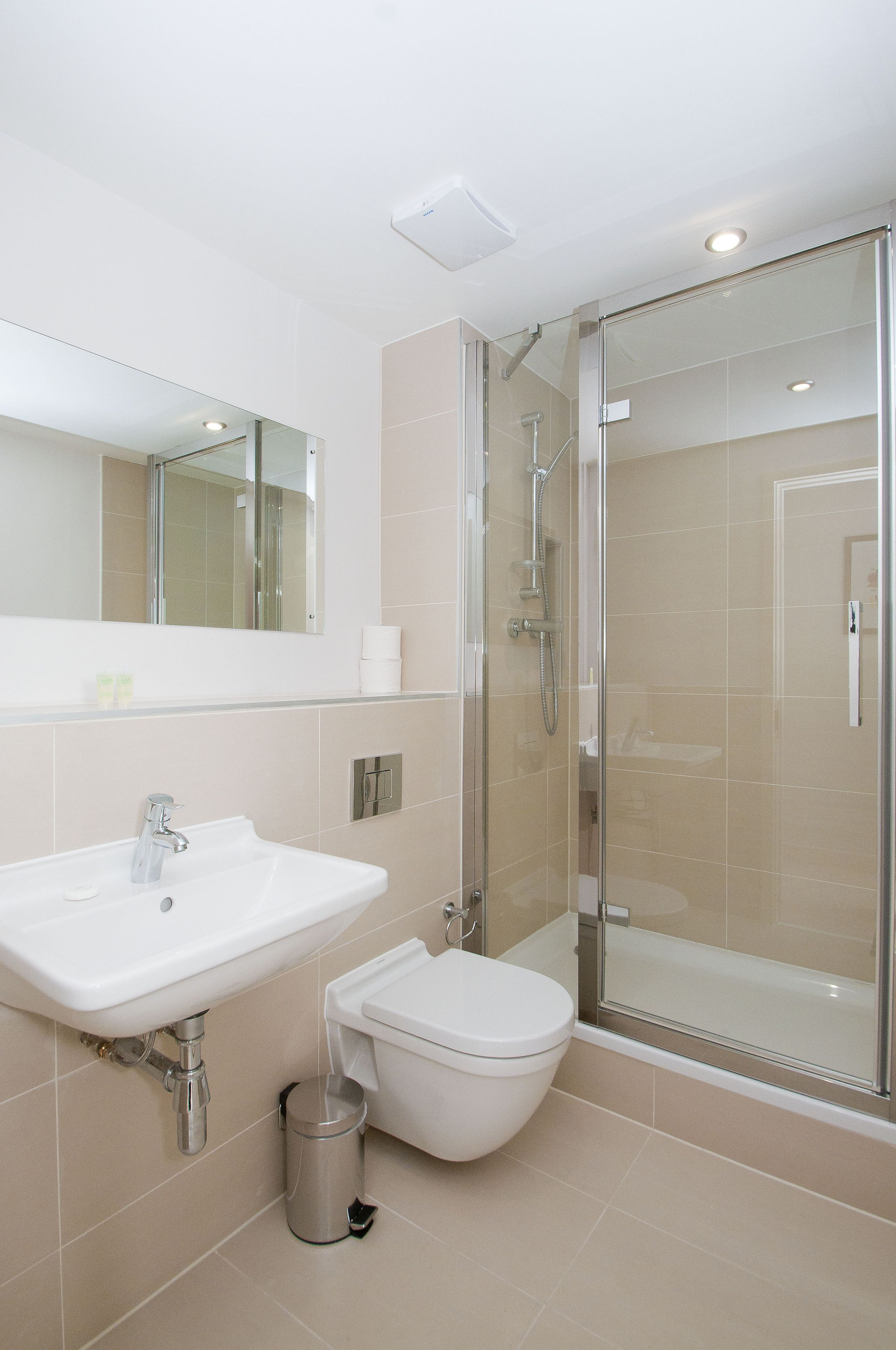 A modern bathroom with a sink, toilet, and glass-enclosed shower.