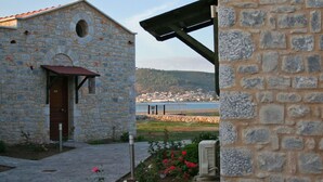 Un edificio de piedra con una puerta marcada “401” y vistas a un pueblo costero.