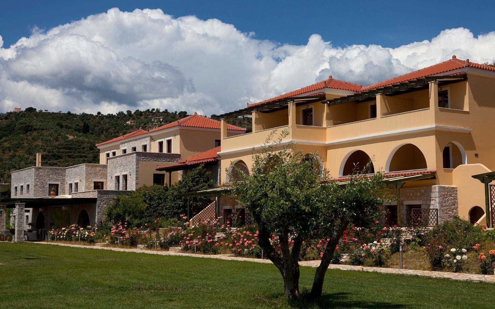 A hotel with multiple buildings featuring red-tiled roofs and arched windows.