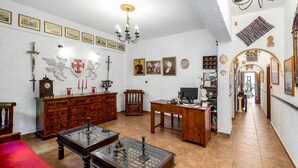Una stanza con un armadio in legno, un tavolo con piano in vetro e un tappeto rosso.