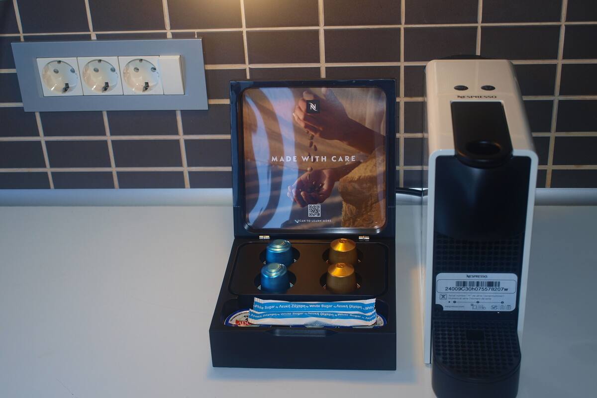 Eine Nespresso-Kaffeemaschine mit Display, Pod-Halter und einer Kapsel.