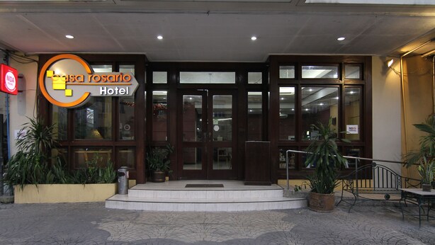L'entrada de l'Hotel Casa Rosario, amb un vestíbul empitjorat de pedra, grans portes de vidre i plantes en testos.