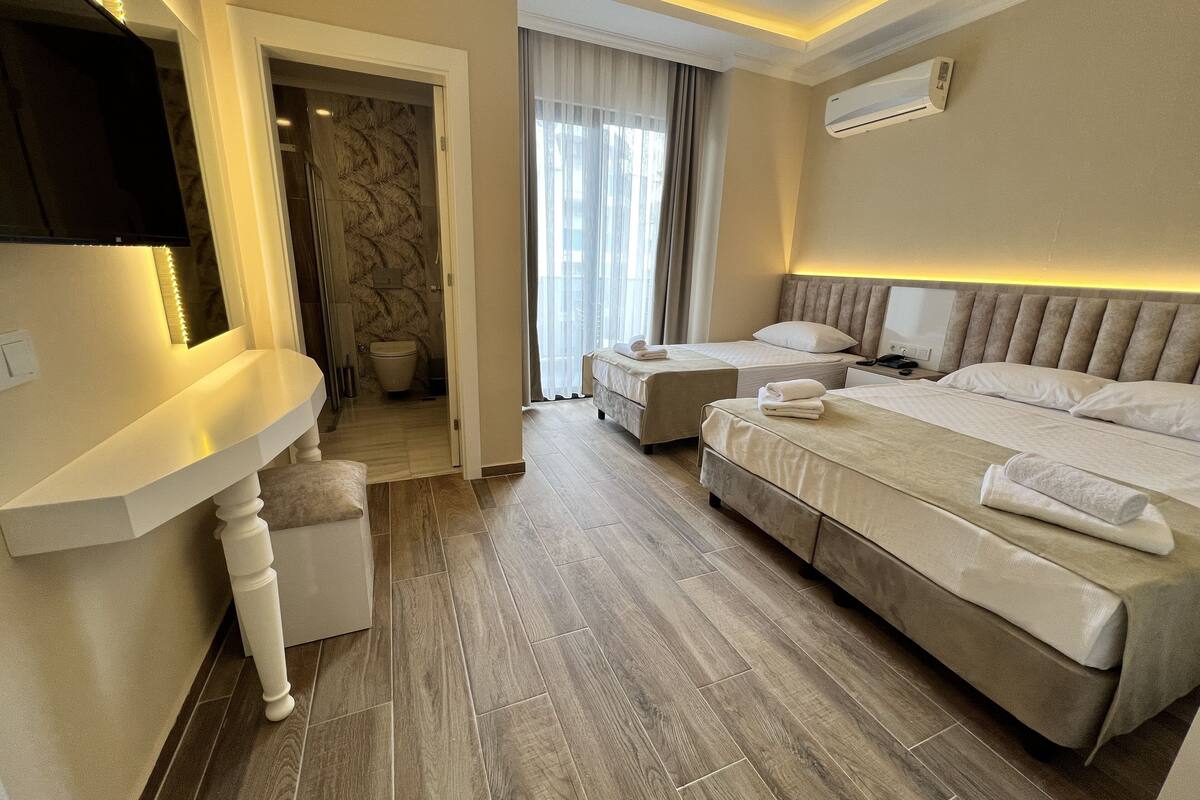A hotel room with a large bed, a desk, and a bathroom.