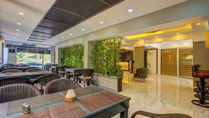 A modern hotel lobby with indoor seating, a large plant wall, and a well-lit ceiling. - Miss Cleopatra Hotel (Alanya)