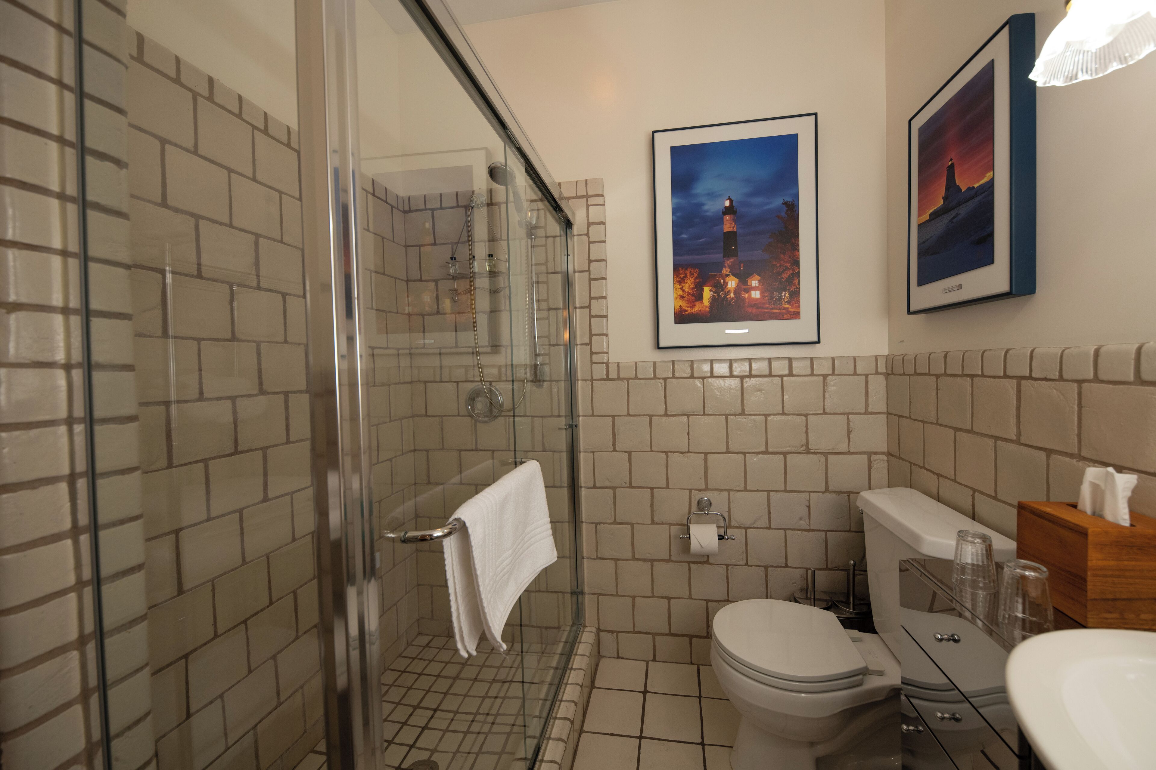 Un bagno con doccia vetrata, un water e un lavandino.