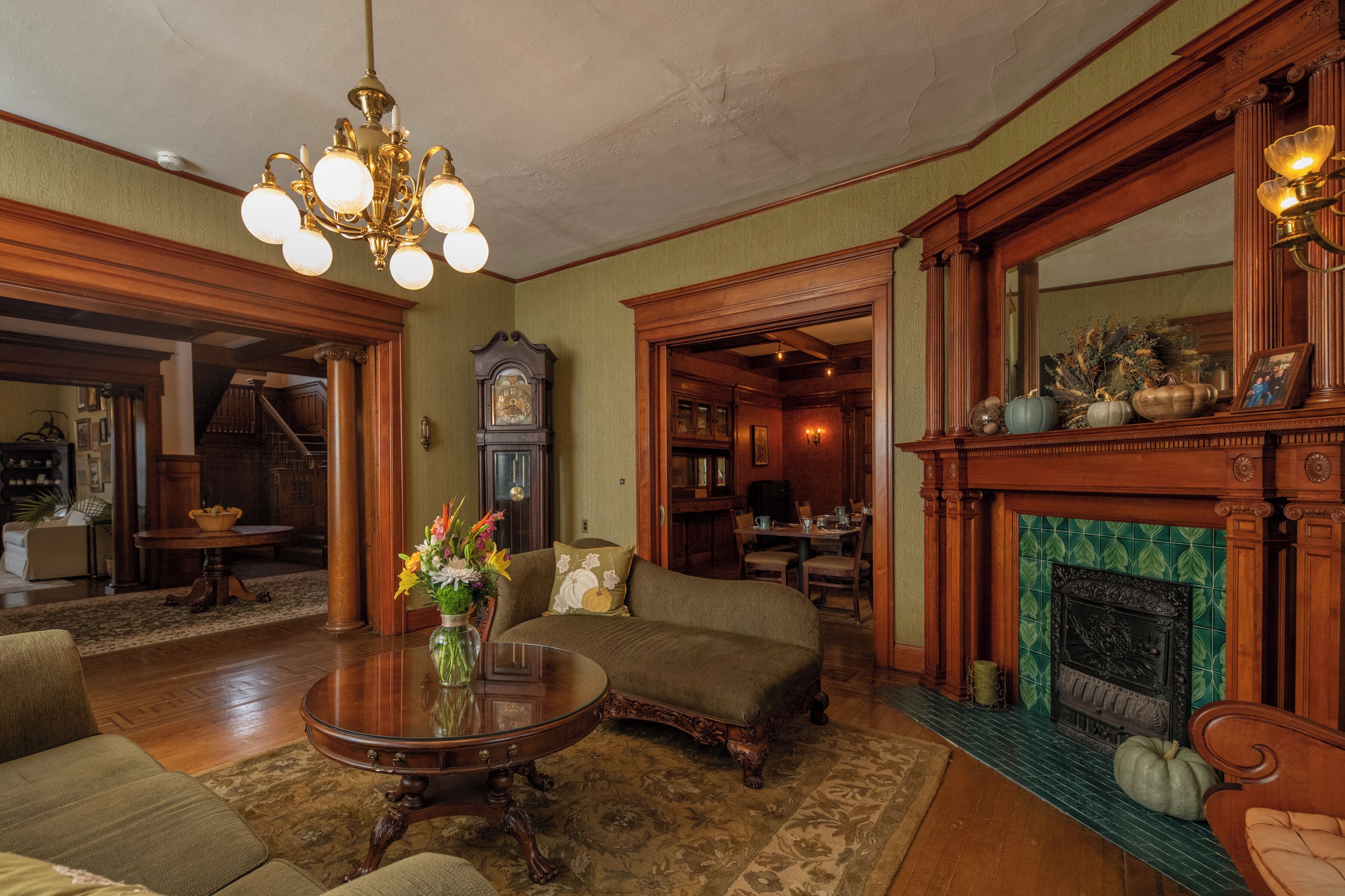 Un salon traditionnel avec une cheminée, des meubles en bois et un lustre.