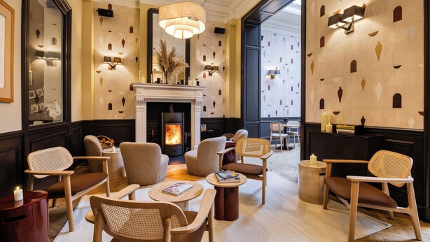 Un salon moderne doté d’une cheminée, de sièges confortables et de motifs décoratifs sur les murs.