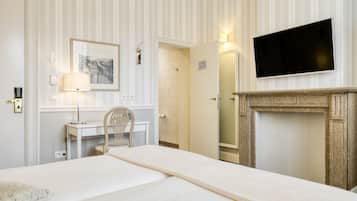 Une chambre d’hôtel équipée d’un lit, d’un bureau, d’une chaise, d’une télévision et d’une cheminée.