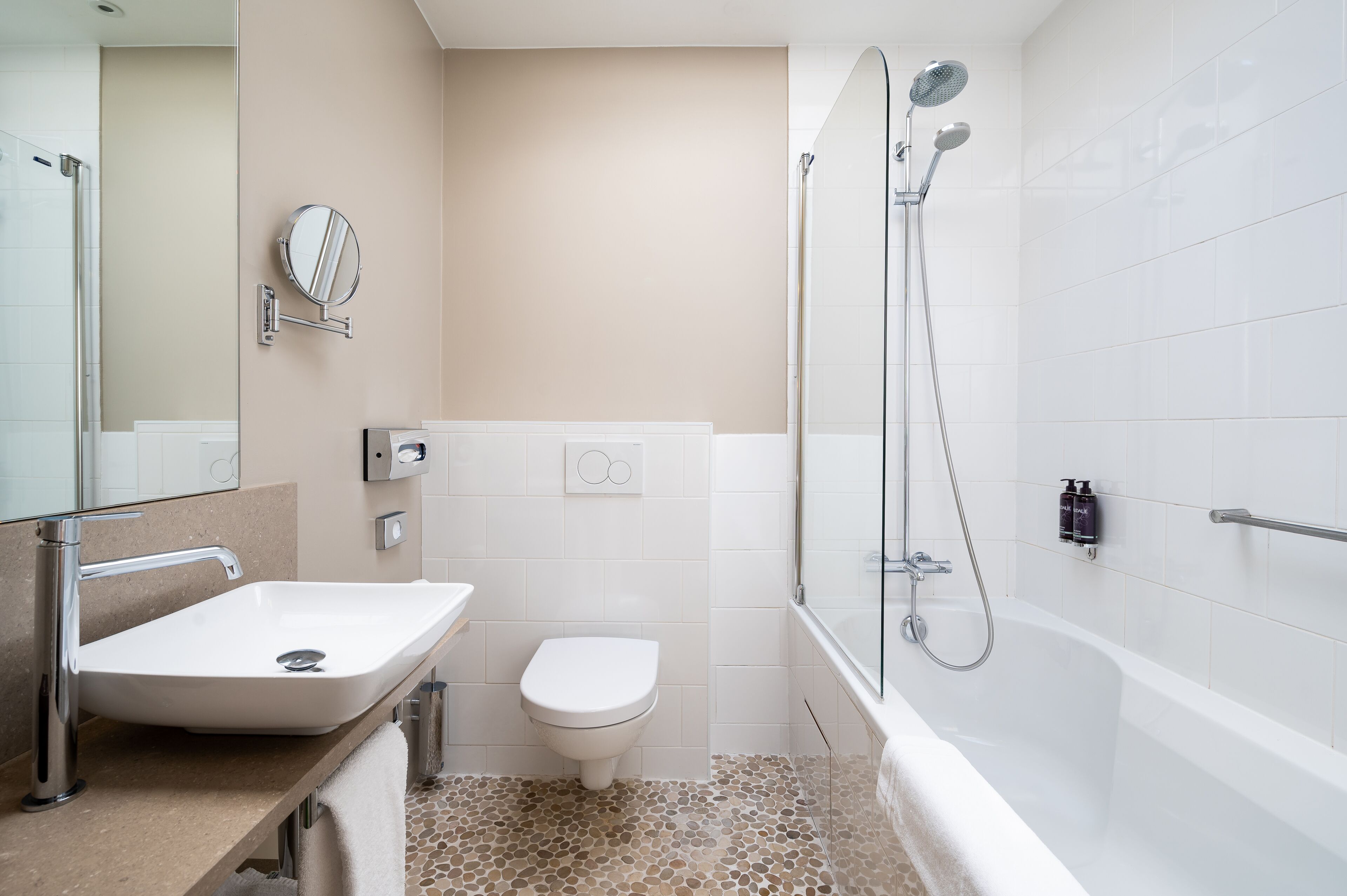 Un baño moderno con lavamanos, inodoro y bañera blancos.