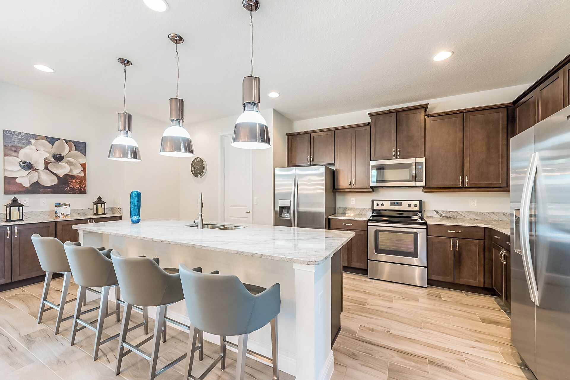 A modern kitchen with a central island, stainless steel appliances, and pendant lighting.