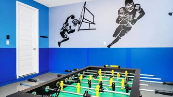 A foosball table in a room with blue walls and a white door.
