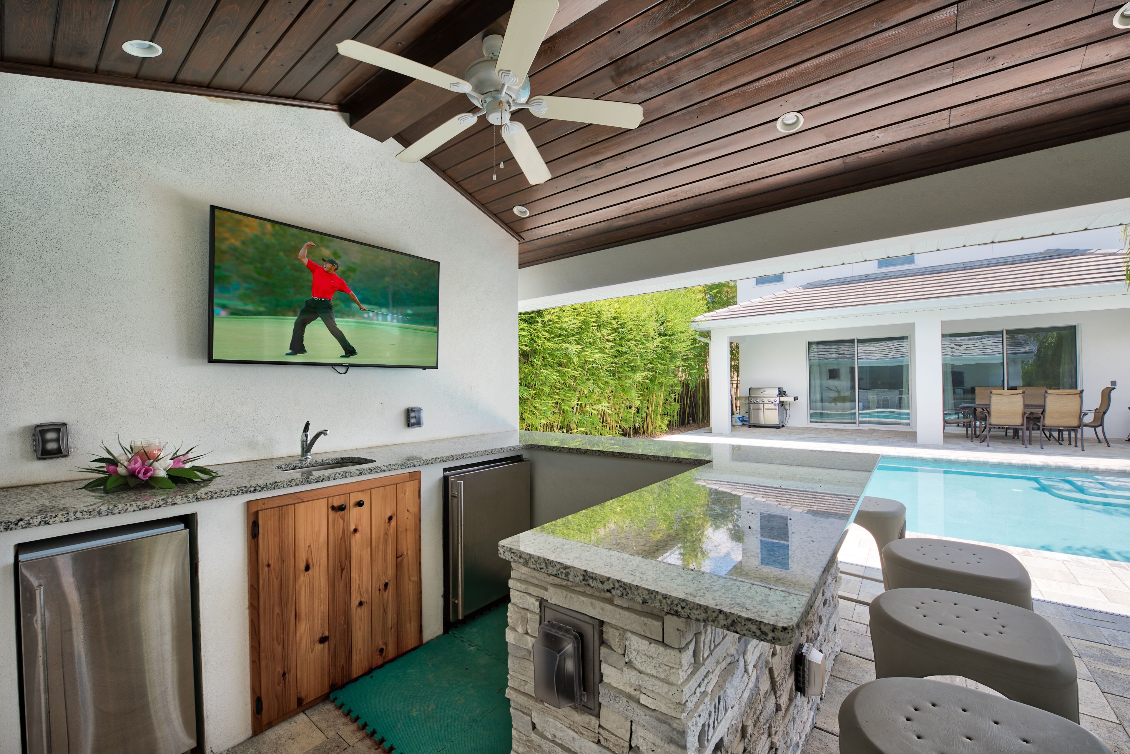 Una cocina moderna con una isla de piedra, armarios de madera y un refrigerador integrado.