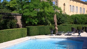 Una piscina con un edificio de piedra al fondo.