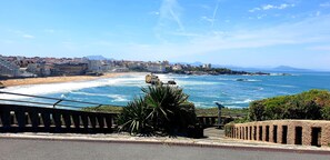 A coastal cityscape with a beach, rocky outcrops, and a clear sky. - Hôtel Au Bon Coin (Biarritz)