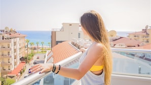 A balcony with a view of the sea and buildings. - Kleopatra Arsi Hotel (Alanya)