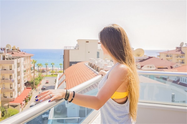 A balcony with a view of the sea and buildings.