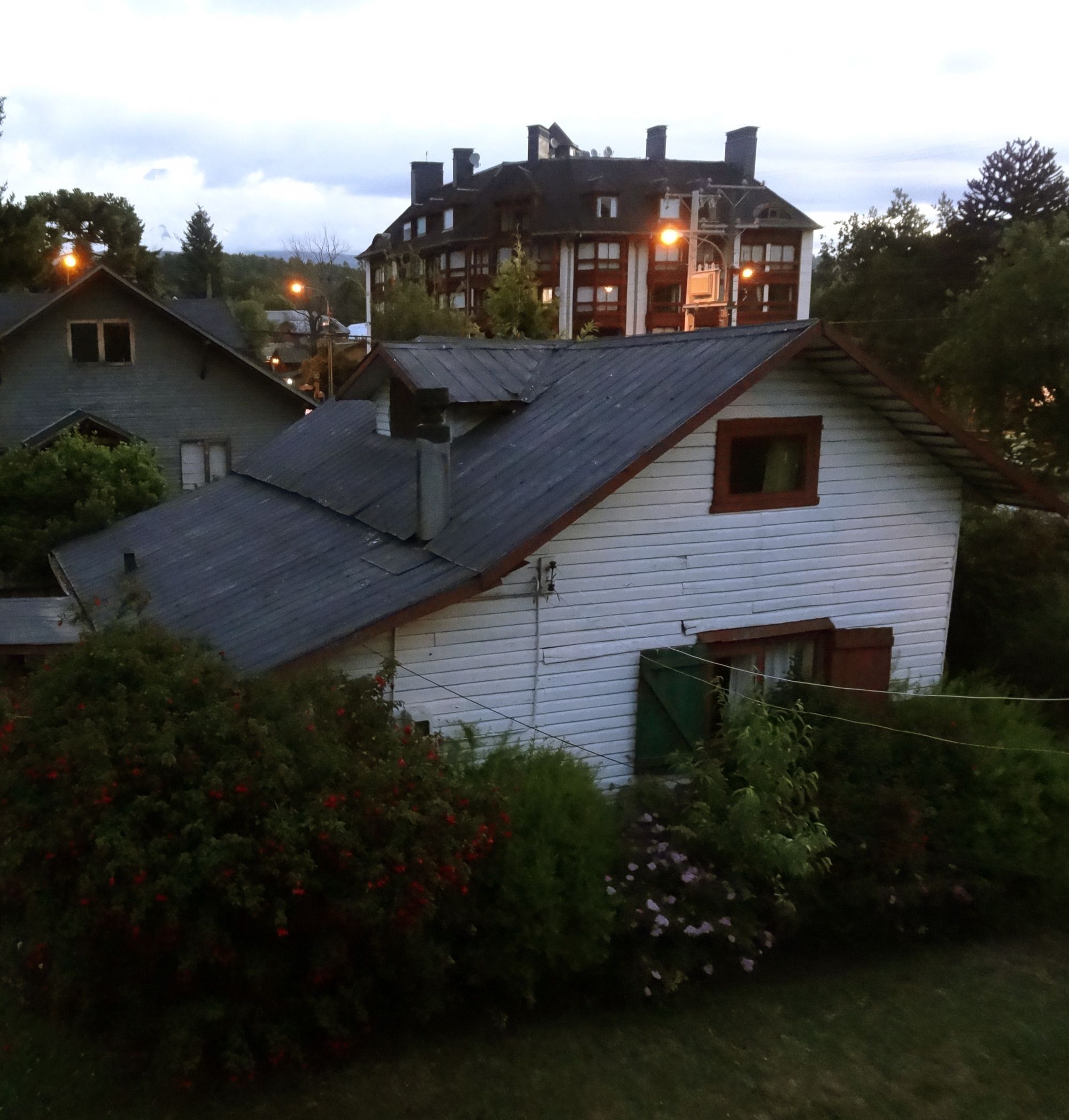 A two-story house with a sloped roof, a chimney, and a small window.