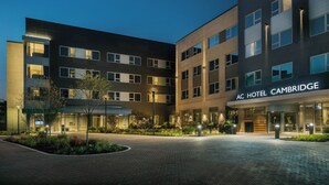A modern hotel with a flat roof, multiple windows, and a well-lit entrance.