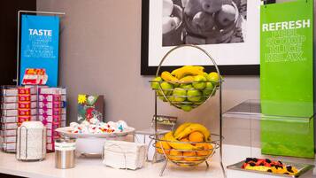 Un área de bufé con diversas frutas y acompañamientos.