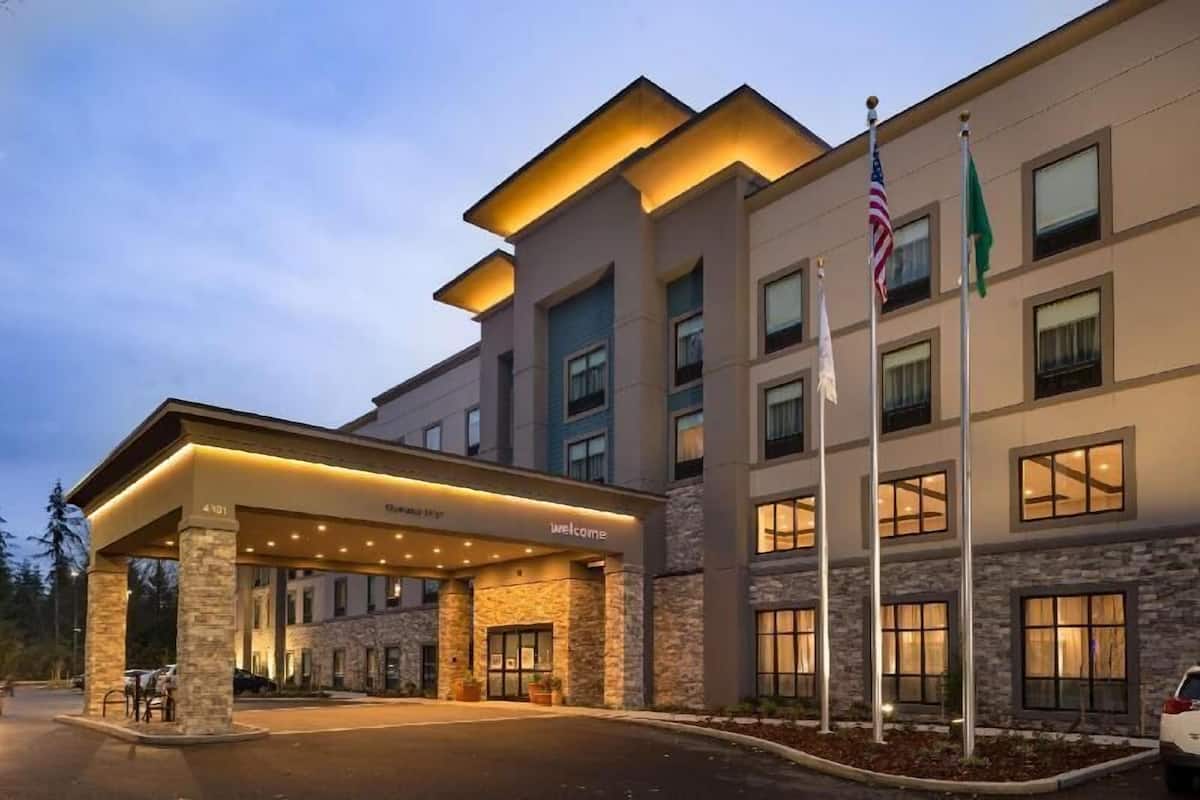 Ein modernes Hotel mit überdachter Eingangspartei, mehreren Stockwerken und Flaggen.