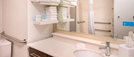A bathroom with a sink, mirror, towel rack, and toilet.