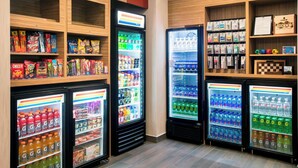A vending area with multiple refrigerated display cases stocked with snacks, drinks, and other items.