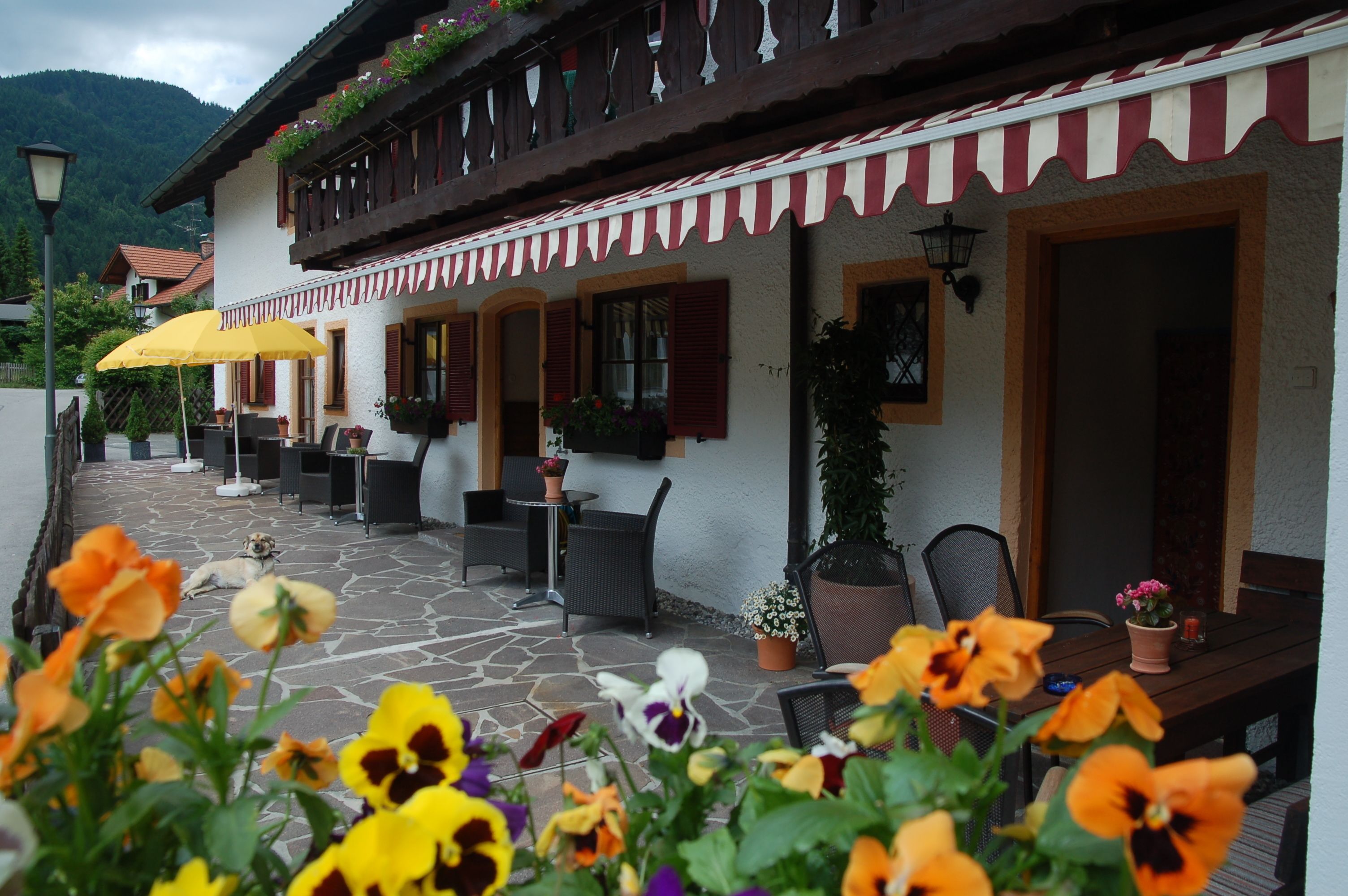 Un edificio de estilo europeo tradicional con mesas al aire libre y arreglos florales.