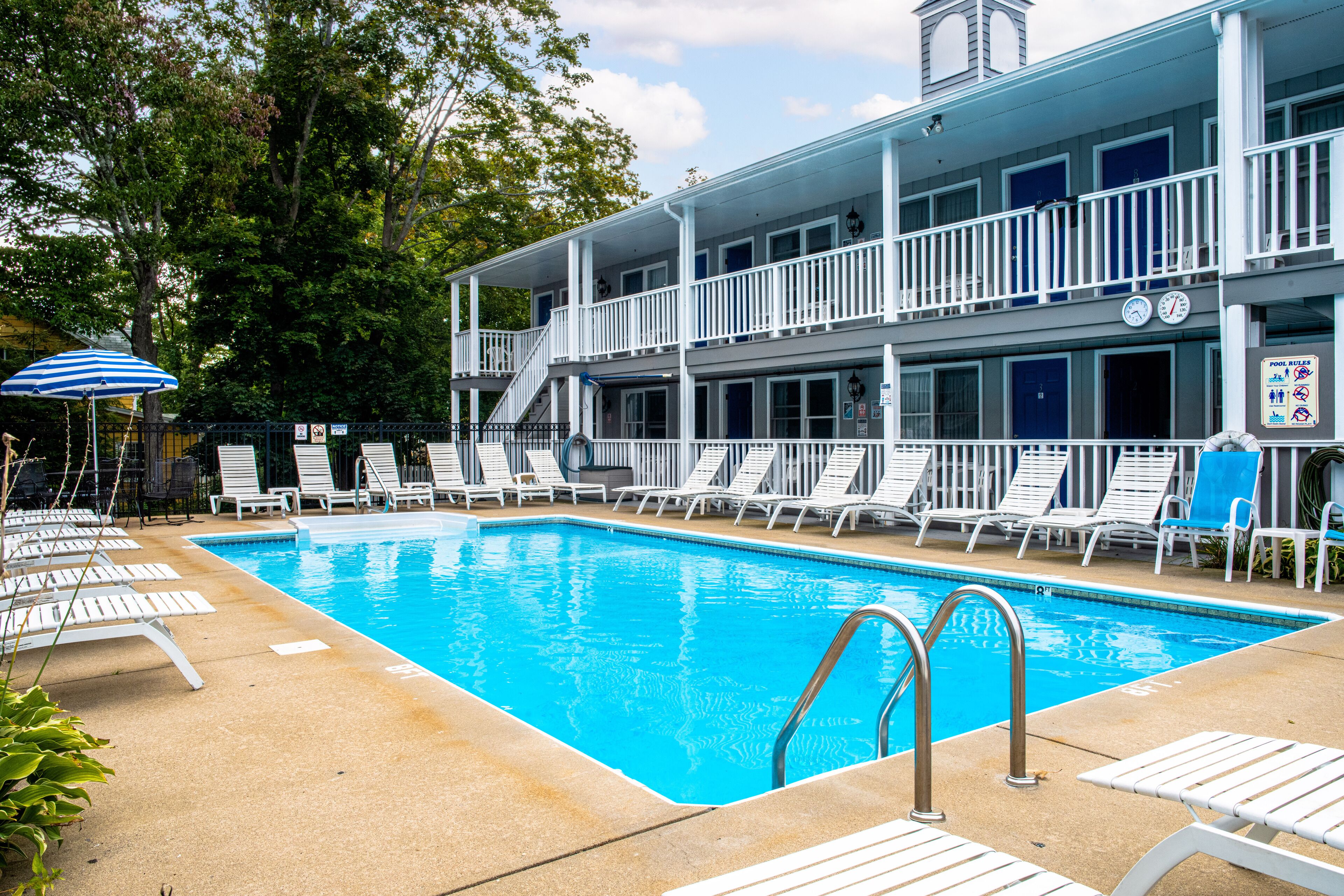 En säsongsöppen utomhuspool och solstolar