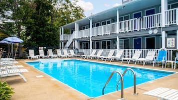 En säsongsöppen utomhuspool och solstolar