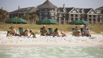 Aan het strand, wit zand, ligstoelen aan het strand, parasols