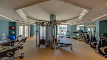 A gym with cardio machines, weight equipment, and exercise balls.