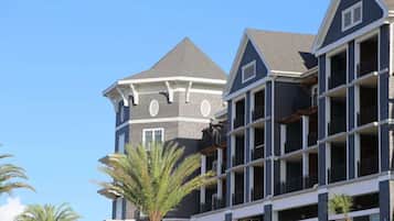 A multi-story hotel with a dark facade, multiple balconies, and a prominent tower with a pointed roof.