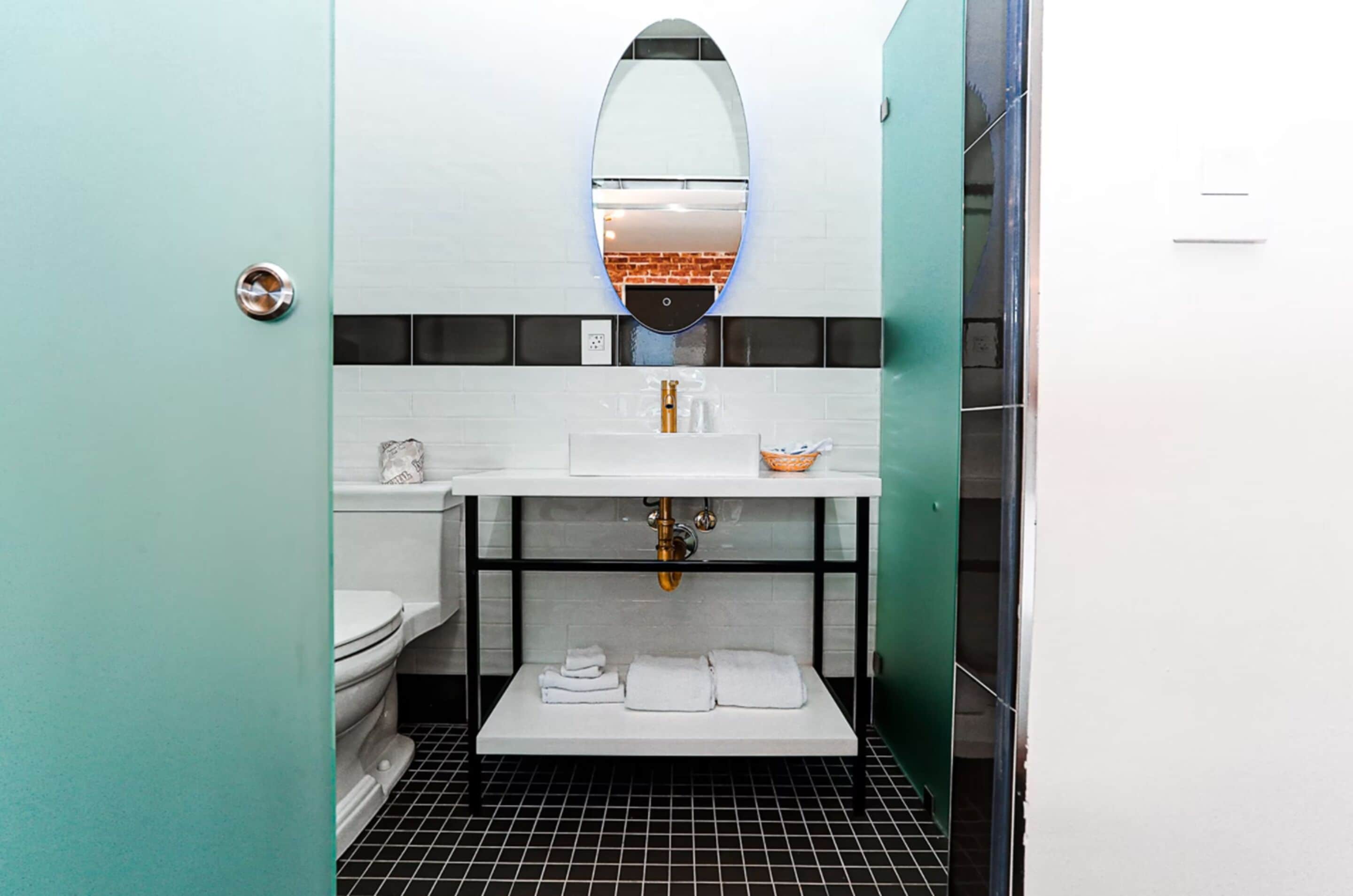 Ein modernes Badezimmer mit einem weißen Waschbecken, einem Spiegel und Fliesenboden.