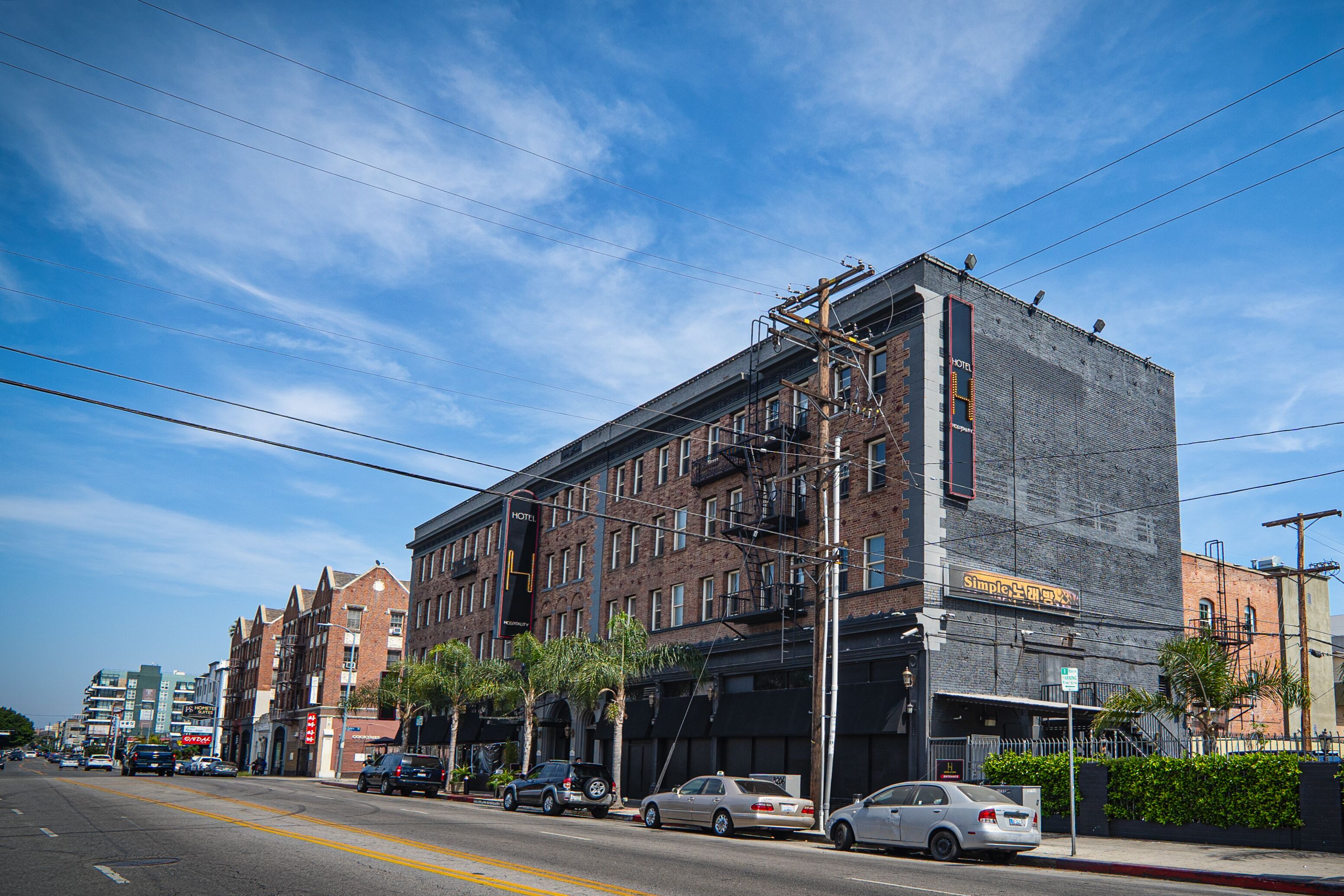 A multi-story hotel with a brick facade, multiple windows, and a visible fire escape.
