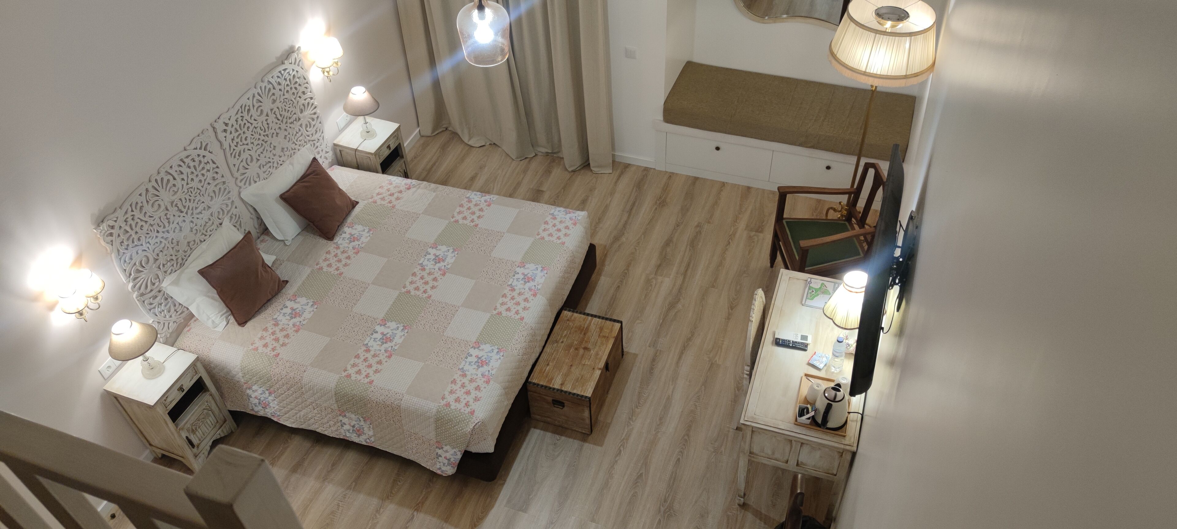 Un dormitorio con cama, mesitas de noche, escritorio y silla.